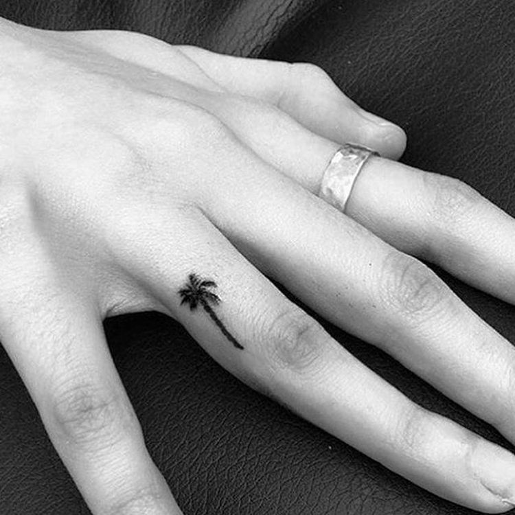 White ink love tattoo on the right ring finger