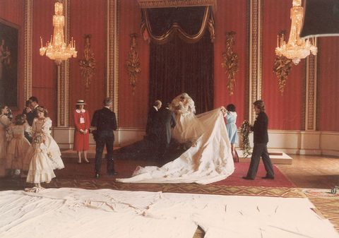 <p>The wedding gown's designers, Elizabeth and David Emanuel, arrange the dress before formal photos.</p>