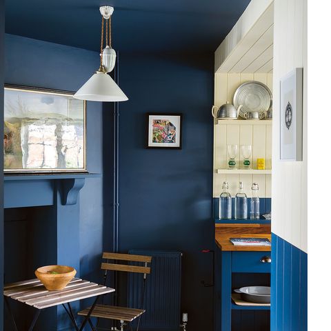 <p>More than the walls were painted blue here—check out the ceiling and the fireplace. "Using one color in a confined area makes it feel bigger," says Joa Studholme, author of Farrow &amp; Ball's book <em data-redactor-tag="em" data-verified="redactor"><a href="https://www.amazon.com/Farrow-Ball-How-Decorate/dp/1784720879" target="_blank" data-tracking-id="recirc-text-link">How to Decorate</a></em>, who adds that if the mantel were white, it would dwarf the room. Another reason to go monochromatic? It helps mask not-so-pretty stuff like exposed pipes or a radiator (use a forgiving eggshell finish). The half-painted walls mark the transition into the kitchen and break up all that navy.</p><p><strong data-verified="redactor" data-redactor-tag="strong">RELATED: <a href="http://www.redbookmag.com/home/decor/g4538/cheap-home-makeover/" target="_blank" data-tracking-id="recirc-text-link">How to Do a Home Makeover Without Breaking the Bank</a></strong><br></p>