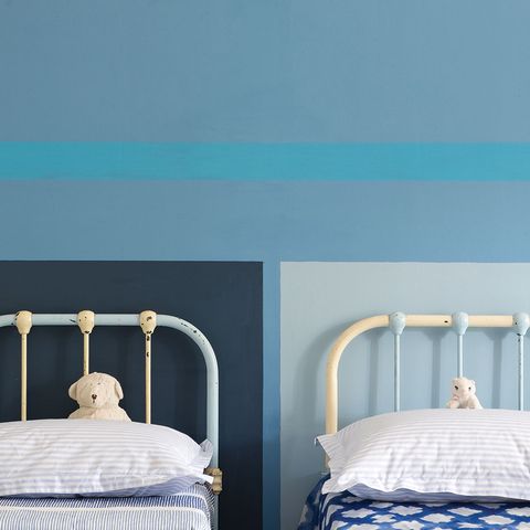 <p>Blocks of color behind a headboard—or any furniture— add instant interest. For crisp lines like these, measure and lightly mark in pencil every few inches along the painted wall. Then connect the marks with strips of painter's tape. Before you paint your second color, run a small brush over the tape edge and along the wall with your original color, says O'Neill. This will create a barrier that prevents the second color from bleeding through, so you get a clean, straight line. Once it's dry to the touch, slowly pull the tape at a 45-degree angle—a quick tug can lift up a chunk of paint. </p>