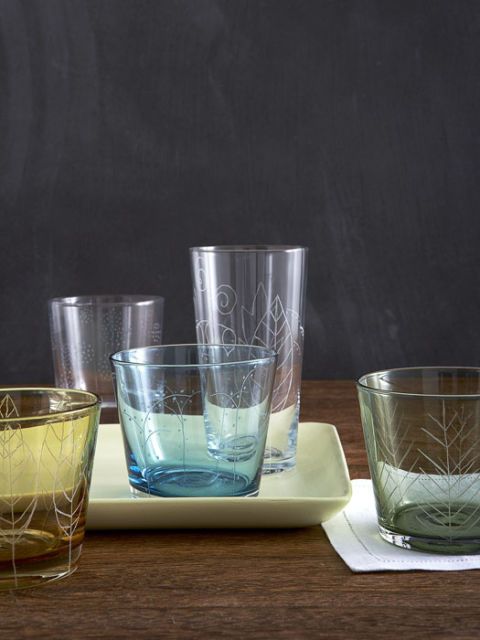 multicolored glassware that has been etched with leafy designs on table
