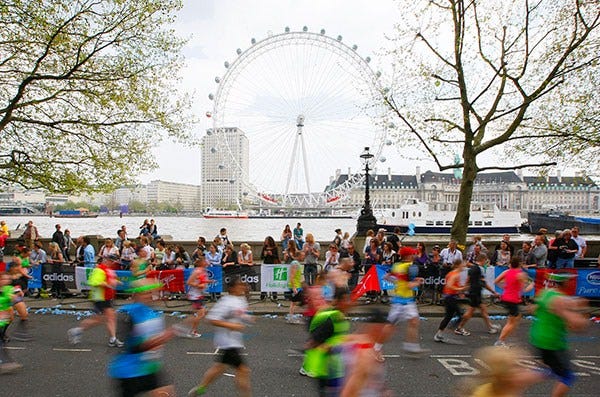 Ferris wheel, People, Recreation, Endurance sports, Crowd, Quadrathlon, Competition event, Outdoor recreation, Urban area, Amusement ride, 