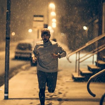 young man out running in the snow at christmas