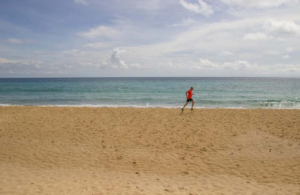 uomo corre in spiaggia