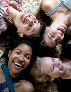 four smiling girls lying on the ground