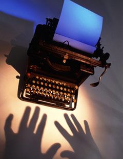 shadow of hands above a typewriter