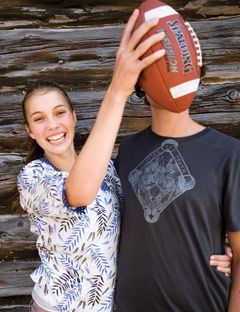 girl holding football in front of guys face
