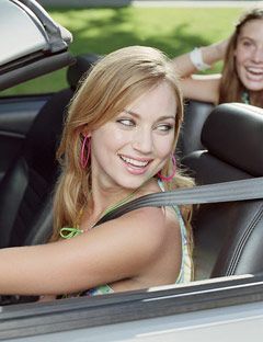 girl driving car with a friend in the back