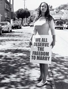 girl holding sign that says we all deserve the freedom to marry