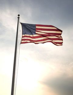 american flag on a pole blowing in the wind