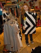 abigail breslin holding up black and white dress at a store