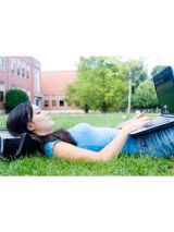 girl lying in grass with laptop