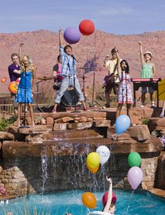 cast of high school musical performing in front of a pool