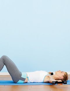 a girl lying down with weights held out on both sides of her