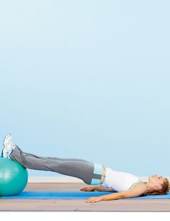 a girl stretched out with her legs elevated on an exercise ball
