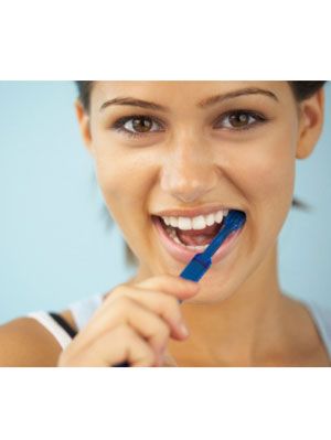 girl smiling with toothbrush in her mouth