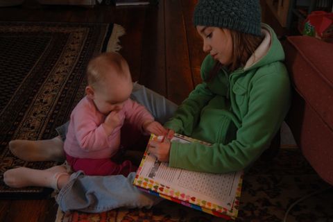 Photo of little girl doing work with little one.