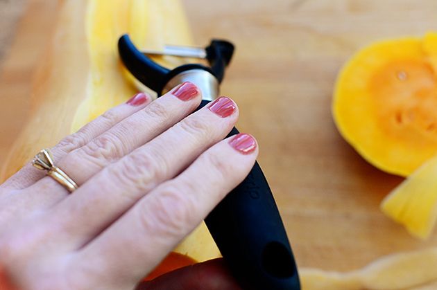 Female hands making butternut squash noodles with a vegetable peeler.Top  view Stock Photo - Alamy