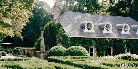 "The guesthouse was a falling-down garage with a tree growing through it when I first discovered it," interior designer Stephen Sills says of the four-bedroom, 2,500-square-foot outbuilding behind the parterre at Hi-Low Farm, his 22-acre estate in Bedford, New York. The main house, a 1920s white shingled colonial, was once dubbed "the chicest house in America" by Karl Lagerfeld. Sills bought it 25 years ago, when the entire property, then in bank foreclosure, was dilapidated and in disrepair. "There was an instant magical quality about it," Sills says, the cadence of his deep voice slow and melodic, with certain words punctuated by his Oklahoma accent. "I knew there was something special going on here." And so Hi-Low Farm, with its fertile bowl-shaped land, became a lifelong reclamation project for the venerated designer, now 62, who counts Vera Wang, Lauren duPont, Anna Wintour, and the Rockefeller family among an impressive bold-faced client list.The Sills aesthetic is simple and exacting, as evidenced here and in a new book, Stephen Sills: Decoration (out this month from Rizzoli)—a refined palette matched with a visually arresting collection of furniture and objects. Pieces from different countries, centuries, even civilizations conjoin in a singular symphonic vision of contemporary design. "Well, why can't you have all of it?" Sills asks. "Why can't you have the modernity of great Italian design with great 18th-century furniture? That is design for our time now." It is this aesthetic that propelled Sills to the top of his field, and perhaps nowhere is this vision more clearly synthesized and fulfilled than here, at this weekend refuge, which Sills calls his "laboratory."The guesthouse, with its porthole windows inspired by David Hicks's house in the South of France, has been a favorite focus of Sills's design tinkering. (Illustrious guests have included Tina Turner and André Leon Talley.) It is now in its second (or third) incarnation; Sills is currently joining the second floor, once the caretaker's apartment, to the finished rooms downstairs. But as with any design-leaning mind, "finished" isn't the best description of the space. From a new paper tacked onto a wall to the architectural model of the main house with two future additions sitting on the dining room table, evidence of constantly emerging ideas is everywhere. The most recent structural addition to the estate, a 1910s greenhouse from an arboretum in Boston, has been placed among the specimen trees of a previous owner, the writer and garden enthusiast Helen Morgenthau Fox. "I can feel her here, especially in the trees. I think she would be pleased with what we've done. We've respected the property, but we've brought it up to today," Sills says. "Decoration doesn't move as fast as fashion, but it does change every 10 years, and you have to refresh and keep current with what is happening." One gets the feeling that however soft and lulling his voice may be, Sills's intense blue eyes never lose their sharp focus on the future—or on the past.The son of a doctor and a music professor, Sills grew up in Durant, Oklahoma. Even as a child he pored over design books and magazines, often traveling to the closest international bookstore, a Doubleday in Dallas. "I wanted to have a beautiful, glamorous life and do something creative, andlive it," he says. "That was my dream." After graduating from Southern Methodist University, Sills went to design school at the University of North Texas. Upon graduation his parents sent him to Paris, where he would live for three years. "When I was a teenager I was looking at Gae Aulenti and thinking, That's the coolest architect happening," Sills says. "I was a real modernist until I went to Paris for the first time and I saw a house that Lorenzo Mongiardino had done for Countess Cristiana Brandolini, and that changed my whole attitude." Sills's parents eventually sent an envoy to collect him and bring him back to America.Beginning his career with Jerry Oden in Dallas and then moving to New York, Sills designed with James Huniford for nearly 25 years. The duo built an impressive portfolio of both residential and commercial projects before separating in 2008. Architectural Digest editor Mitchell Owens, who once followed them through a Paris flea market, said, "It's almost like a sixth sense. Not only do they choose the best example of a style, but it always turns out to be something that was owned by some incredible person. There's always this nexus of history, society, craftsmanship, and international chic."Back in the guesthouse this nexus is realized. "I wanted to make a cozy, comfortable place, but nothing sweet or sentimental," Sills says. The hand-painted canvas ceiling was inspired by Pauline de Rothschild's patterned tiled floor at Château Mouton Rothschild. The floors are made of Canadian marble blocks and painted white, while two shades of tinted plaster were used on the walls. "I wanted to make a sort of nebulous, modern background and put beautiful objects in here, because I love objects. I think objects are the things in decoration that make a room." The Robert Morris felt sculpture was brought in to add "visual clarity," Sills says. "You know, this object was made in the '60s, and it is still so startling when you see it." The Spanish lantern, made from an old sugar container and the belts of soldiers from the Spanish-American War, was purchased at Art Basel. The 18th-century Italian round-back chairs were bought 25 years ago at Sotheby's, while the contemporary straw chair, made by a young Korean artist, was discovered at the last booth at a furniture fair in Paris. A pair of English twig tables, initially passed over at a gallery on Pimlico Road because they were too expensive, turned up at a modest English furniture sale in New York. And a long-sought-after 19th-century French wine-tasting table that once belonged to Christian Dior was found at Jean-Paul Beaujard in Paris."It's funny with objects. If you're really passionate, and you really understand your sensibility, and you're patient, they will come to you," Sills says. "That's what I love about the magic of objects. You never really own anything in this world, but you can be lucky enough to possess something for a time, and enjoy it, and then it goes on to another person to enjoy.""There was an instant magical quality about it. I knew there was something special going on here.""There's always this nexus of history, society, craftsmanship, and international chic," Mitchell Owens said.Above: A former garage, the 1920s building stands behind a parterre planted with boxwoods and lavender.