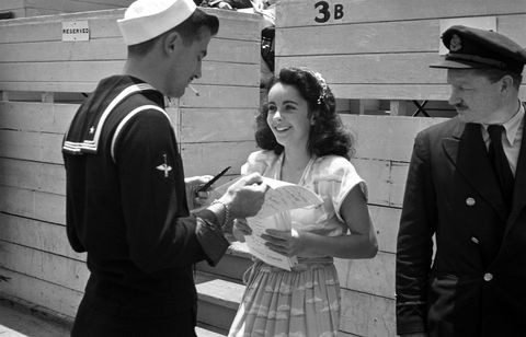 <p>Signing autographs at age 13 in 1945.</p>