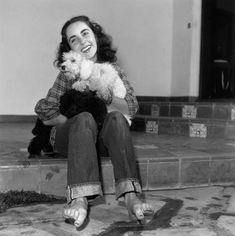 <p>Smiling with a poodle in 1947. </p>