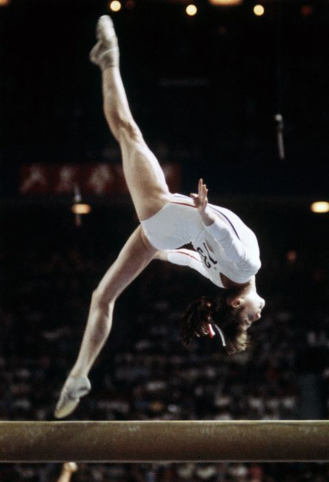 Rumanian champion Nadia Comaneci, aged 14, performs during Olympic beam event 21 July 1976 in Montreal where she was awarded with ten points in two exercices and captured 3 gold medals (beam, uneven bars and general competition). Legendary gymnast, during her career Nadia Comaneci captured four Olympic gold medals (1976 : beam, uneven bars and general competition - 1980, beam) and was the first to score 10 in her discipline. (Photo credit should read STAFF/AFP/Getty Images)