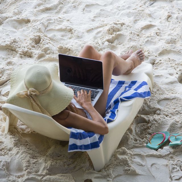 women at the beach with computer