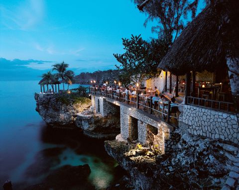 <p>In Negril, Jamaica, Rockhouse Restaurant is perched on an open-air deck on 20- to 30-foot volcanic cliffs jutting above the brilliant waters of Pristine Cove. The menu,&nbsp;overseen by New York City mainstay Miss Lily's executive chef&nbsp;Adam Schop<span class="redactor-invisible-space" data-verified="redactor" data-redactor-tag="span" data-redactor-class="redactor-invisible-space">,</span> features&nbsp;dishes like jerk lobster, oxtail patties, and crispy tofu with ginger soy sauce. "The view looks out west at the sunset and we put a lot of work into lighting it at night so that guests can watch the fish in the reef below," says owner Paul Salmon. While the nighttime view is truly special, Salmon loves breakfast at the restaurant. "I sit at the high table at the end of the bar and kind of perch up there," he explains. "It's very peaceful, particularly in the morning when the sun gets really high in the sky. The water is incredibly blue and it's dead flat and glassy."&nbsp;<br></p><p><a href="http://www.rockhouse.com/eat/" target="_blank" data-tracking-id="recirc-text-link">rockhouse.com</a></p>