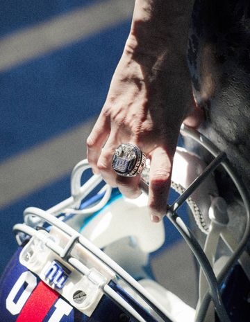 Lizzie Tisch holds New York Giants quarterback Eli Manning's helmet, while wearing her own Tiffany and Co. XLVI 2012 Super Bowl Championship ring.