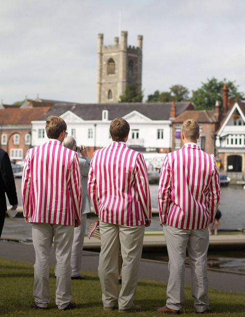 <p>Rowers in their traditional club blazers watch the boats come down the course.</p>