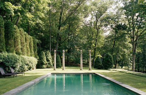 The American limestone columns were found at Michael Trapp in West Cornwall, Connecticut, and provide the visual focal point at the edge of the swimming pool. The lounge chairs are from Brown Jordan.
