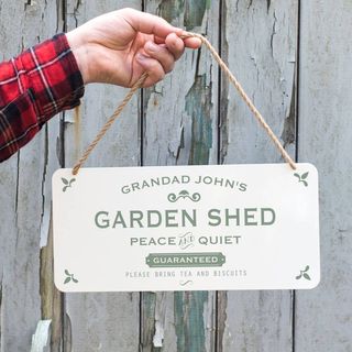 A sign of a personalized metal garden shed