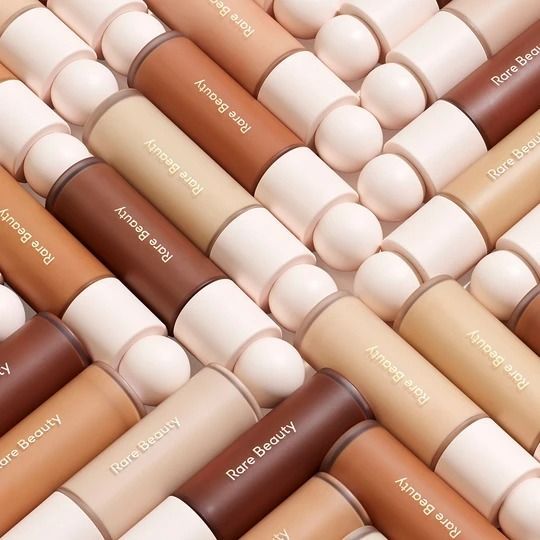 4 of Rare Beauty's Liquid Touch Weightless Foundation lay down in a repeating pattern