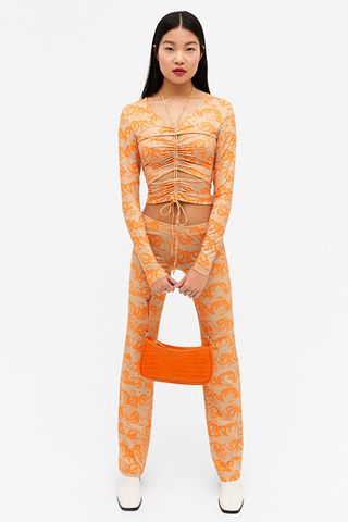 Orange top with ruched front and cut outs