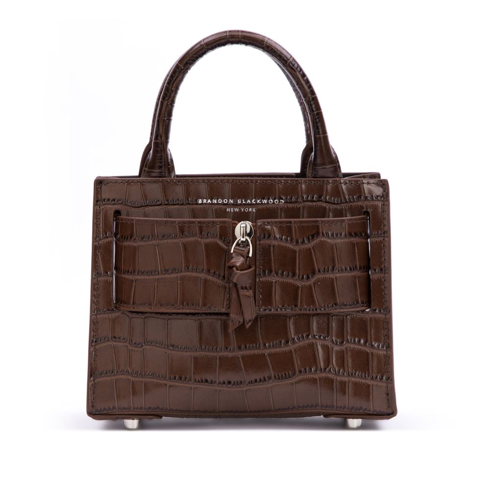 1952 Model in brown full jacket carrying a crocodile handbag by
