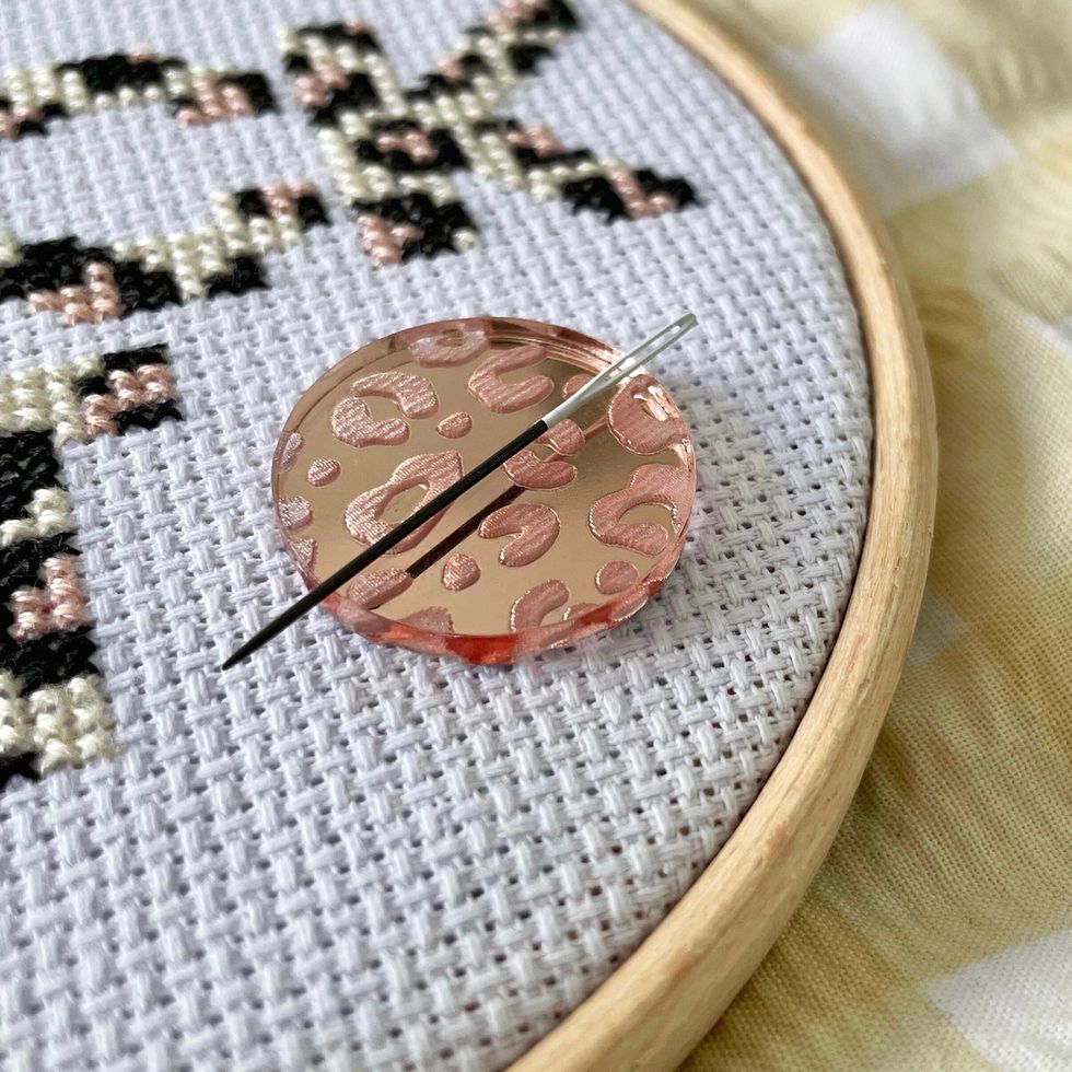 How to use a needle minder for cross stitch and embroidery - Stitched Modern