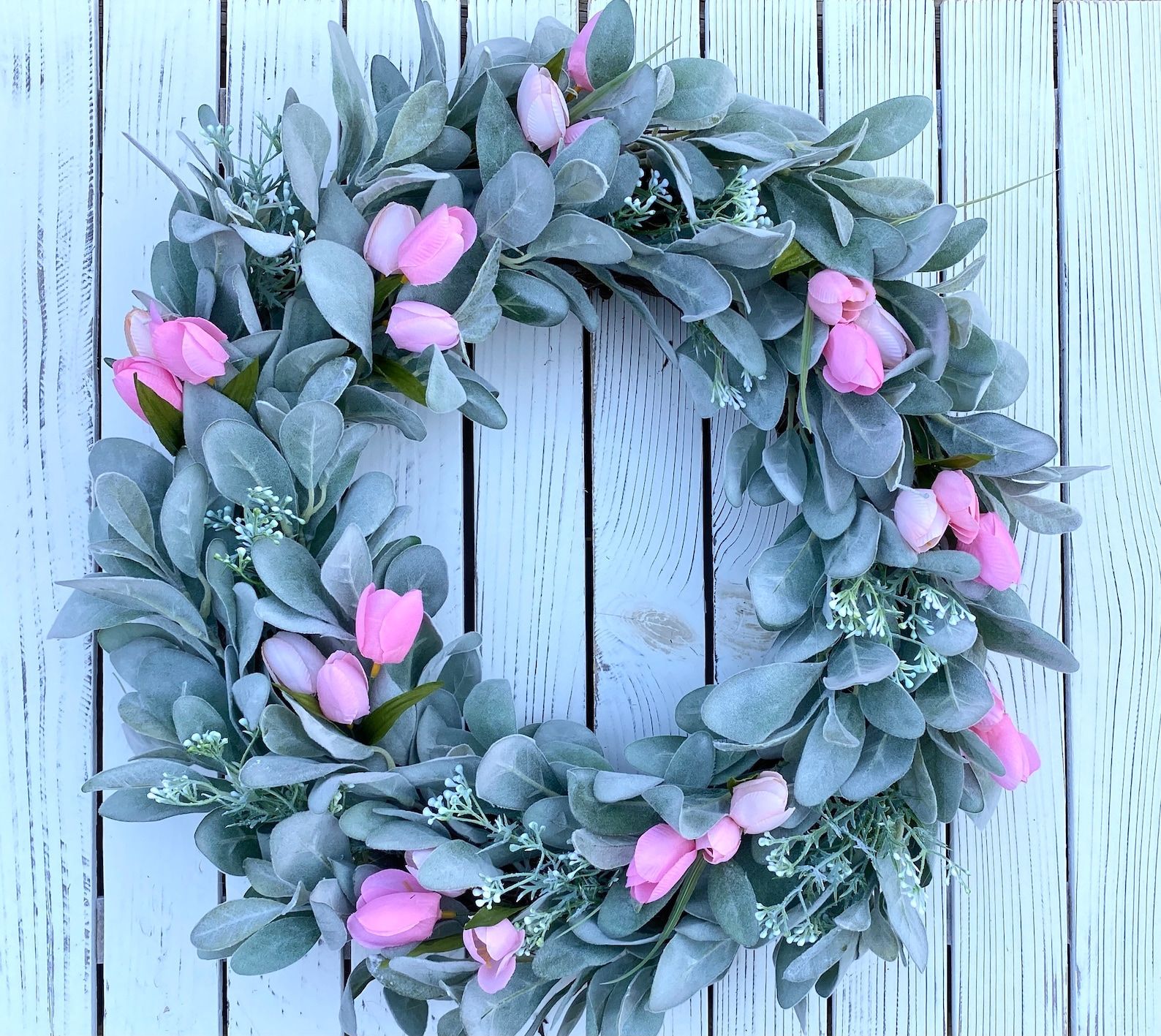 Shades of pink poenies, lambs ear and lavander are planted in a beautiful wall hanger vase. A farmhouse burlap outlets mesh bow adorns this vase.