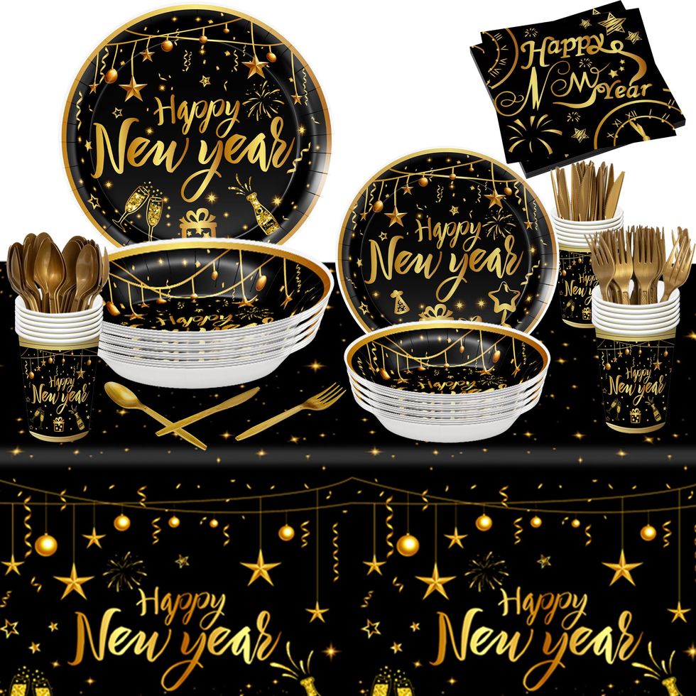 New Years party bottom border with glittery black and gold streamers and  confetti. Top down view on a black background. Stock Photo