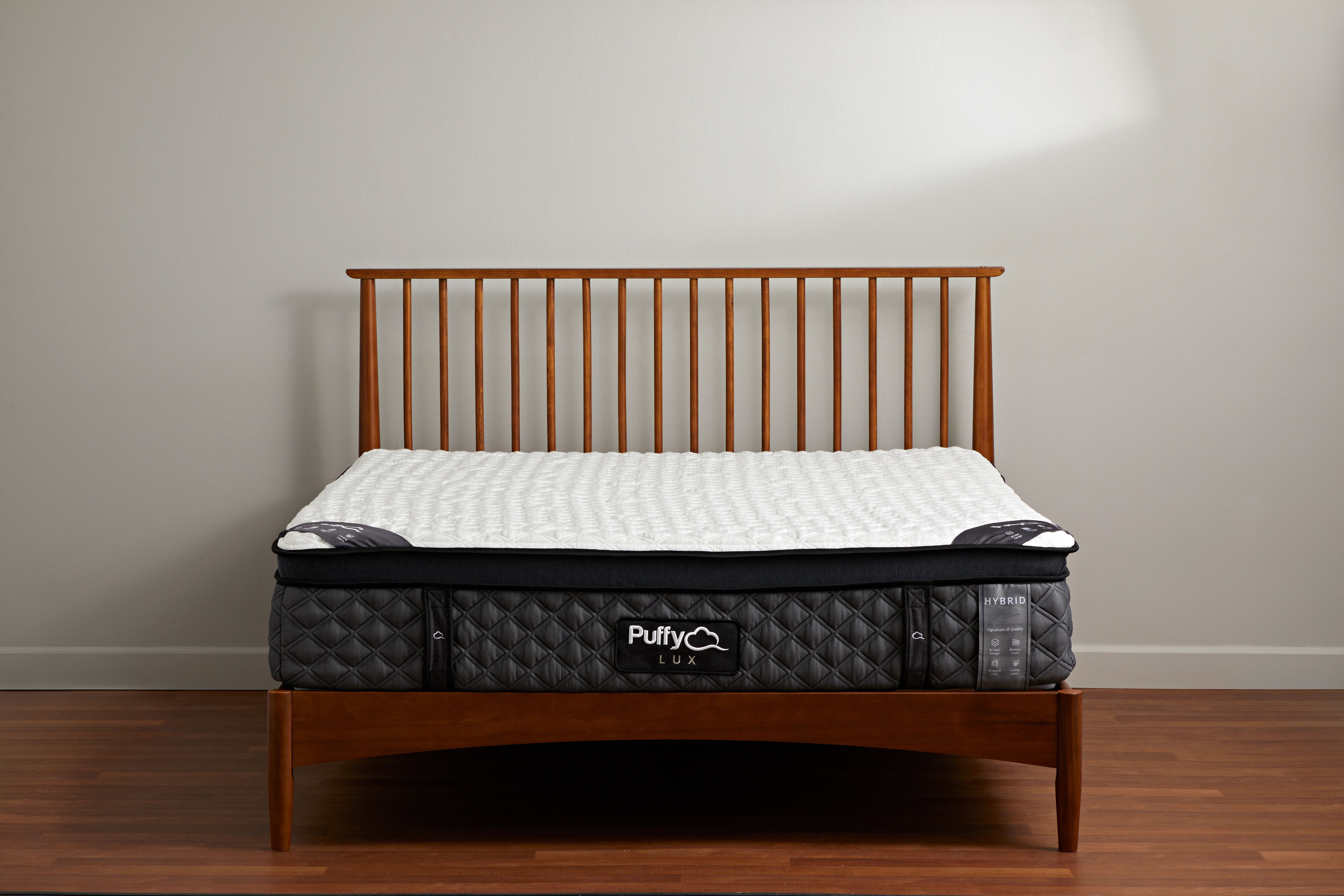 a dark grey and light grey mattress from puffy on a bed frame