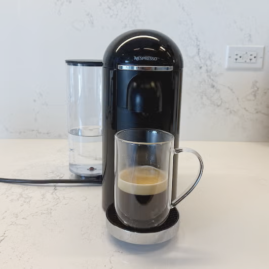 Nespresso coffee machine with a cup of brewed coffee