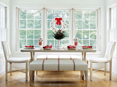 Scandinavian simplicity takes a turn for the tasty with the addition of peppermint candy and popcorn embellishments. Playing off the crimson stripe of the upholstered bench and chairs, the picnic-style plank table is topped off with a red ribbon runner. A centerpiece of seasonal greens and berries becomes the focal point, flanked by a pair of glass vases filled with pieces of swirling candy canes and topped with popcorn balls dotted with hypericum berries.