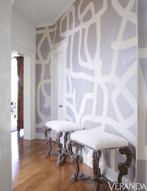 <p>Graphic hand-painted wallpaper and reproduction benches animate the hallway of the master bedroom. Benches in an Old World Weavers fabric, Tara Shaw Maison; wallpaper, Porter Teleo.</p>