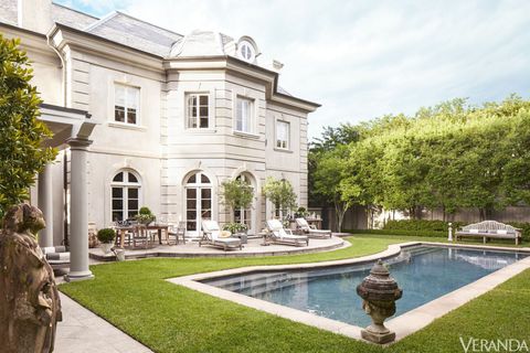 <p>The flagstone pool surround complements the graceful curves of the terrace. Chaises with cushions in a Sunbrella fabric, bench, and chairs, David Sutherland; 19th-century French urn, Tara Shaw Antiques. </p>