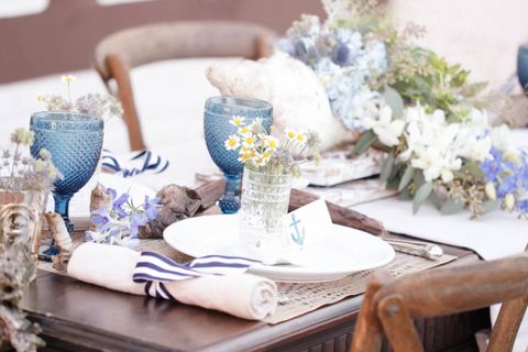 <p>This blue and white tablescape hints at a nautical theme without making it obvious or forced. Whitewashed shells dot the table runner, while the placecards are stamped with tiny anchors.</p><p>Via <a href="http://burnettsboards.com/2013/12/tips-photographing-wedding-details/" target="_blank">Burnetts Boards</a></p>