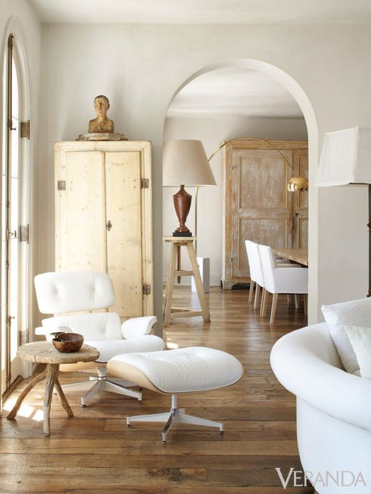 Modern white Eames lounge chair and ottoman with rustic wood stool in French Country living room. Design by Pamela Pierce. #midcenturymodern #eames #modernfrench #frenchcountry #livingroomdecor #pamelapierce