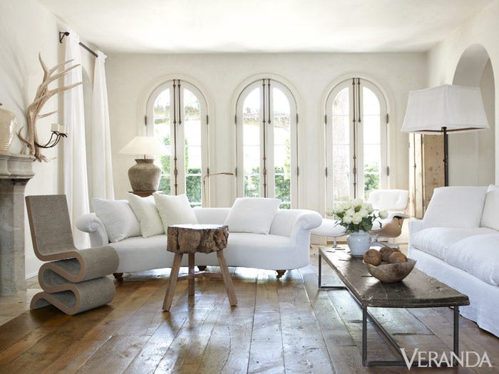 French Country Interior Design Ideas: Pamela Pierce living room with white furniture, rustic coffee table, modern chair and French limestone fireplace. #interiordesign #frenchcountry #livingroomdecor #pamelapierce