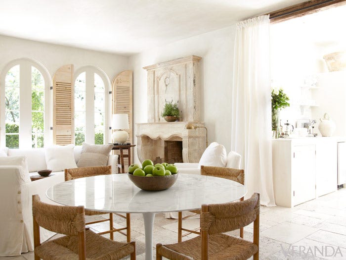 White Interior Design Ideas: French Country living room decor with white sofa, Saarinen table, and French limestone fireplace. Pamela Pierce Houston Home. #interiordesign #decoratingideas #livingroomdecor #pamelapierce
