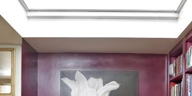In the library entry hangs a tulip painting by Sophie Coryndon. Campbell's fabric is upholstered on her Lehmann bench, named for her grandfather.
