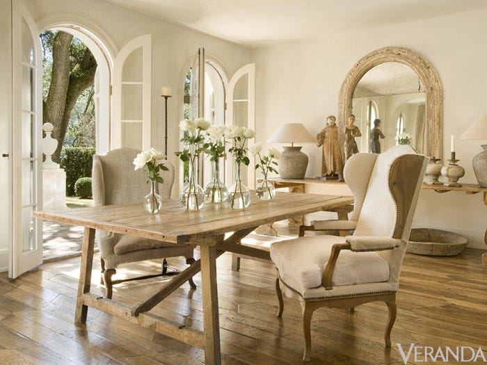 French Country dining room with farm table, wing chairs, and arched French doors to the glorious garden. #frenchcountry #diningroom #pamelapierce