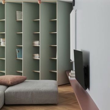 La casa-libreria verde salvia che gioca con il vedo-non-vedo